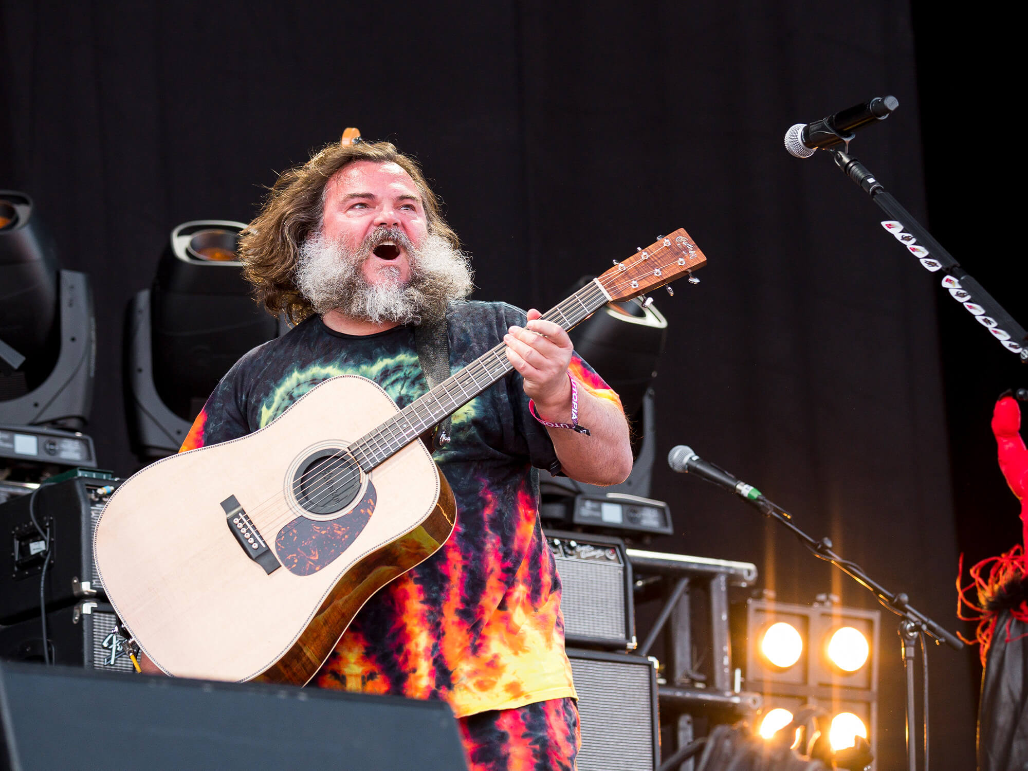 Jack Black on stage holding an acoustic guitar